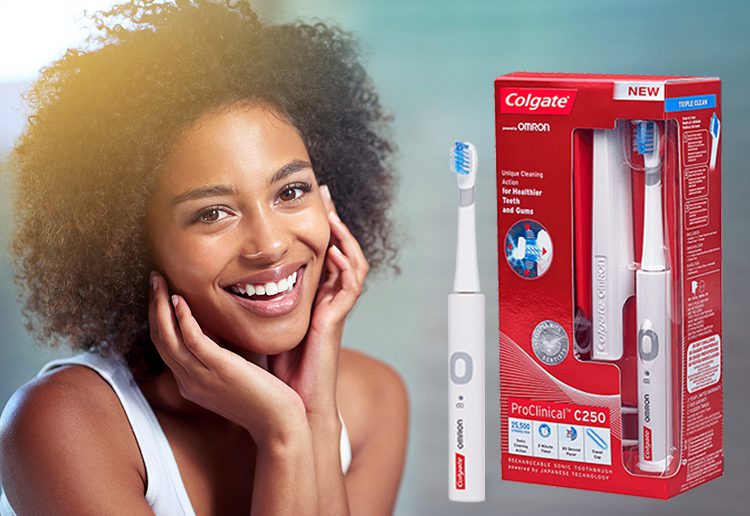 Smiling lady with beautiful teeth with Colgate® ProClinical® C250 Electric Toothbrush in the foreground