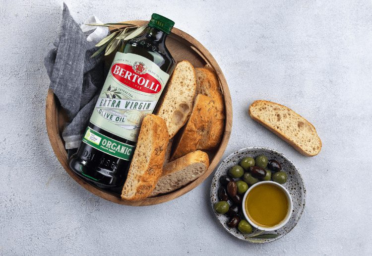 Bertolli Product Review Main Image showing Bertolli Organic Olive Oil in a basket with some bread