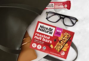 Nice and Natural Roasted Nut Maple & Sea Salt Bars next to a work bag.
